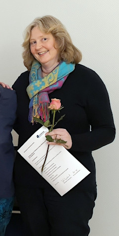 Teilnehmerin mit Urkunde und Rose